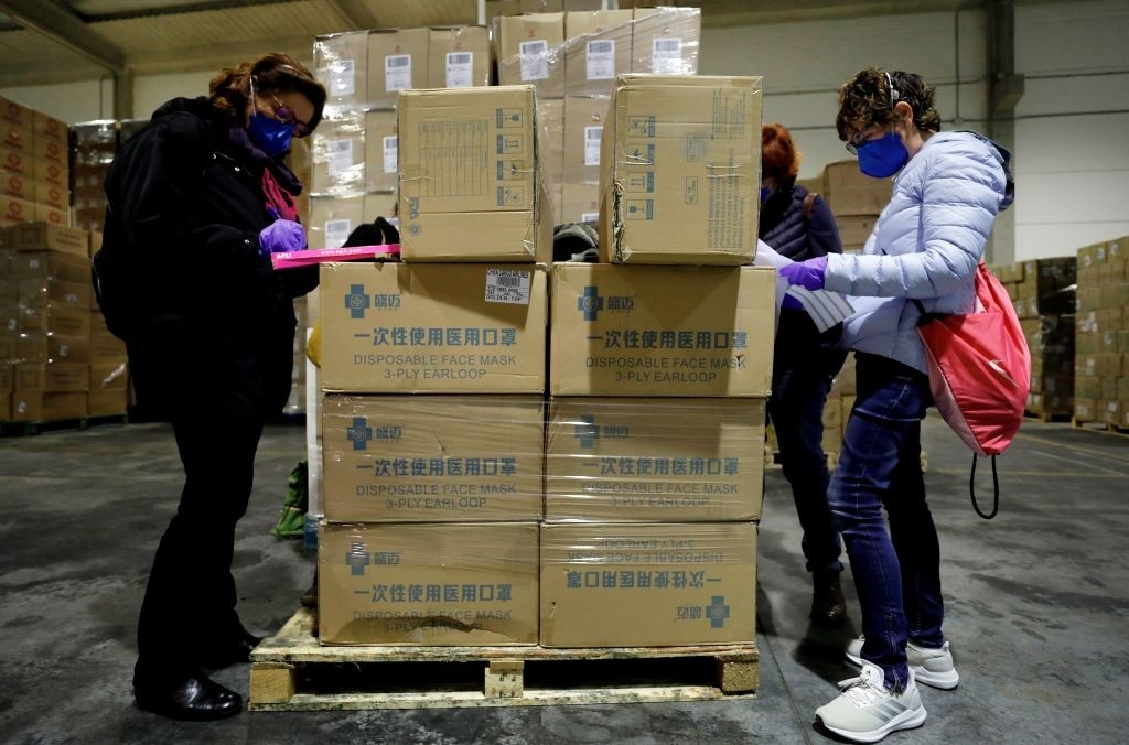 Workers sort out all the personal protective equipment (PPE) received from China at a warehouse in Valencia, Spain, on March 25, 2020. - A total of 3,800,000 masks, 5,000 protective suits and 2,000,000 gloves arrived in Valencia to equip hospitals and elder homes in the need of this material amid the coronavirus outbreak. Spain has signed a multimillion-euro contract with China to acquire medical supplies to fight the coronavirus epidemic, health minister said today. Worth some 432 million euros ($467 million), the deal will cover 550 million masks, 5.5 million rapid test kits, 950 respirators and 11 million pairs of gloves to address shortages in Spain, where the number of deaths reached 3,434 today, overtaking the figure in China where the virus originated late last year. (Photo by Juan Carlos Cárdenas / POOL / AFP) (Photo by JUAN CARLOS CARDENAS/POOL/AFP via Getty Images)
