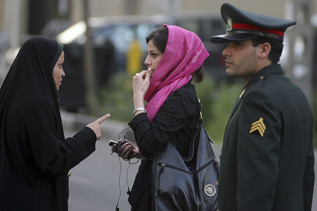 TEHRAN, IRAN - APRIL 22: An Iranian policewoman (L) warns a woman about her clothing and hair during a crackdown to enforce Islamic dress code on April 22, 2007 in Tehran, Iran. Police issued warnings and conducted arrests during an annual pre-summer crackdown, which was given greater prominence this year, according to officials. (Photo by Majid Saeedi/Getty Images) *** Local Caption ***