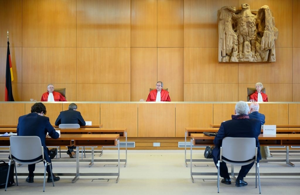 The judges of the German constitutional court (L-R) Peter M. Huber, chairman Andreas Voßkuhle and Doris König sit on May 5, 2020 at the Constitutional court in Karlsruhe, as they give out their ruling that the European Central Bank must clarify a key bond-buying scheme to support the eurozone economy is "proportionate" or else Germany's Bundesbank central bank may no longer participate. - The Bundesbank will be barred from participating in the "quantitative easing" (QE) asset purchase programme in three months' time "unless the ECB Governing Council adopts a new decision that demonstrates in a comprehensible and substantiated manner that the monetary policy objectives pursued by the ECB are not disproportionate," the court said in a statement. (Photo by Sebastian Gollnow / POOL / AFP) (Photo by SEBASTIAN GOLLNOW/POOL/AFP via Getty Images)