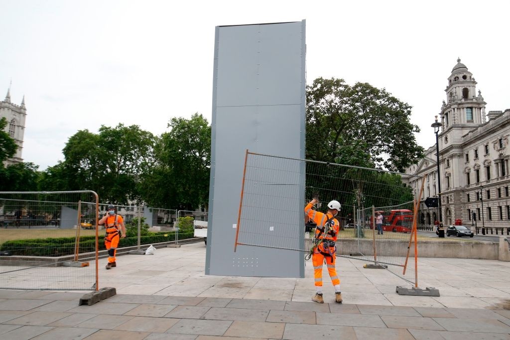 Workers eract fencing prior to removing the boards proteting the statue of former Prime Minister Winston Churchill from vandalism during anti-rascism portests, ahead of the visit of French Presibet Emmanuel Macron, in Parliament Square, central London on June 17, 2020. (Photo by Tolga AKMEN / AFP) (Photo by TOLGA AKMEN/AFP via Getty Images)